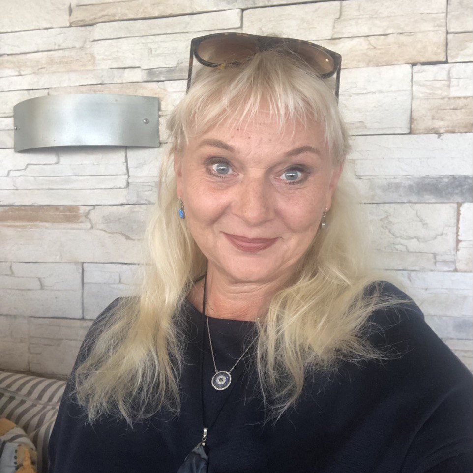 Original photo of blonde woman in straw hat on beach holding iPhone with drone flying behind
